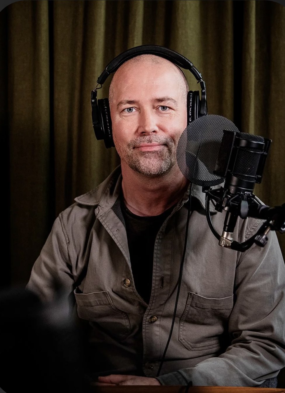 Magnus Ohlsson i studio, med hörlurar och mikrofon framför sig